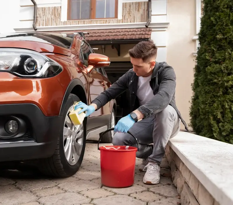 Lavage auto à domicile Le Poujol-sur-Orb : professionnel intervenant sur un véhicule